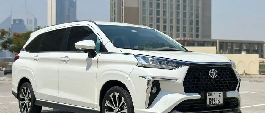 A 2024 Toyota Highlander parked in a lot, available for rent in Dubai and Abu Dhabi as a 7-seater vehicle.