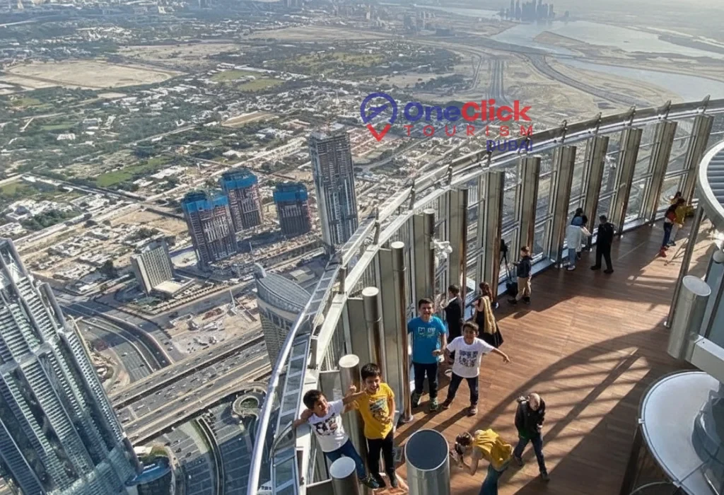 A group of tourists enjoying the city view from the glass observation deck of the Burj Khalifa in Dubai.