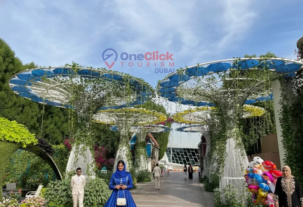 Visitors in elegant attire walking under massive vine-covered umbrella structures.