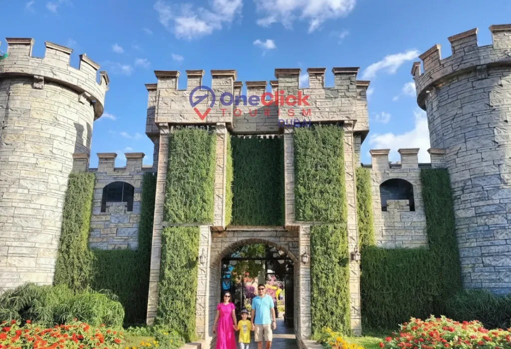 A family walking through the entrance of the iconic floral stone castle in Miracle Garden.