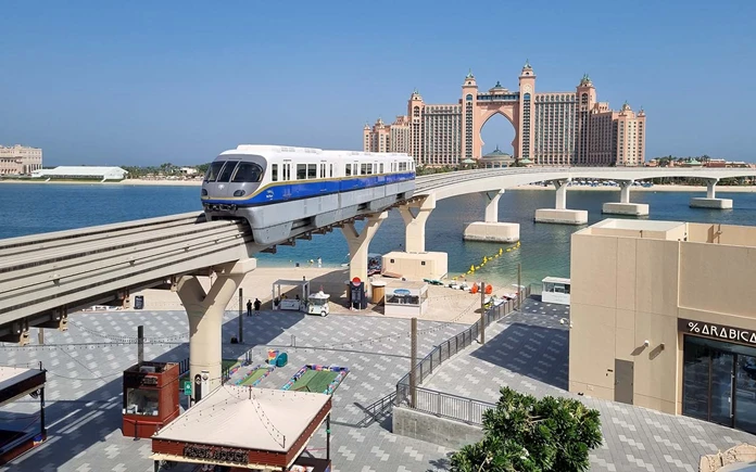 Palm Jumeirah Monorail moving along the track over the water toward the iconic Atlantis, The Palm resort building in Dubai