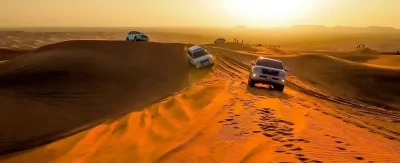 4x4 cars drifting across desert dunes during evening desert safari Dubai