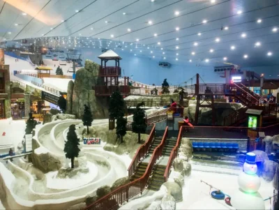 The indoor snow park at Ski Dubai in the Mall of the Emirates, featuring snowy slopes and a mountain-style lodge.